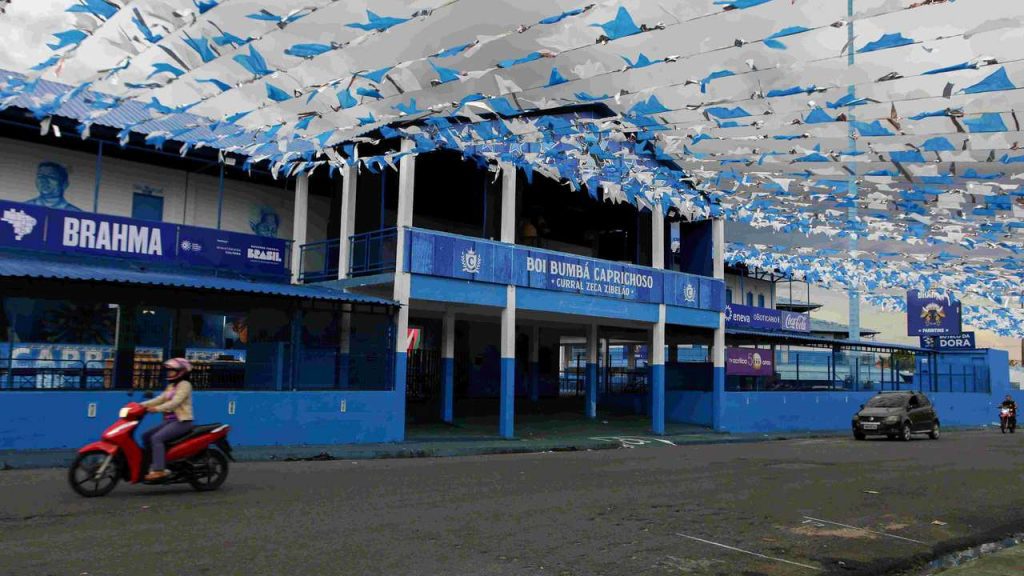Fachada do Curral Zeca Xibelão, palco do Boi Caprichoso, com bandeiras azuis e brancas.
